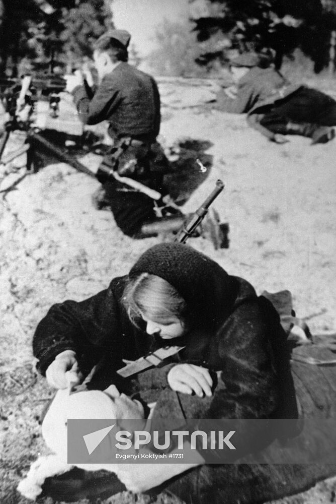 A nurse bandaging a wounded guerrilla