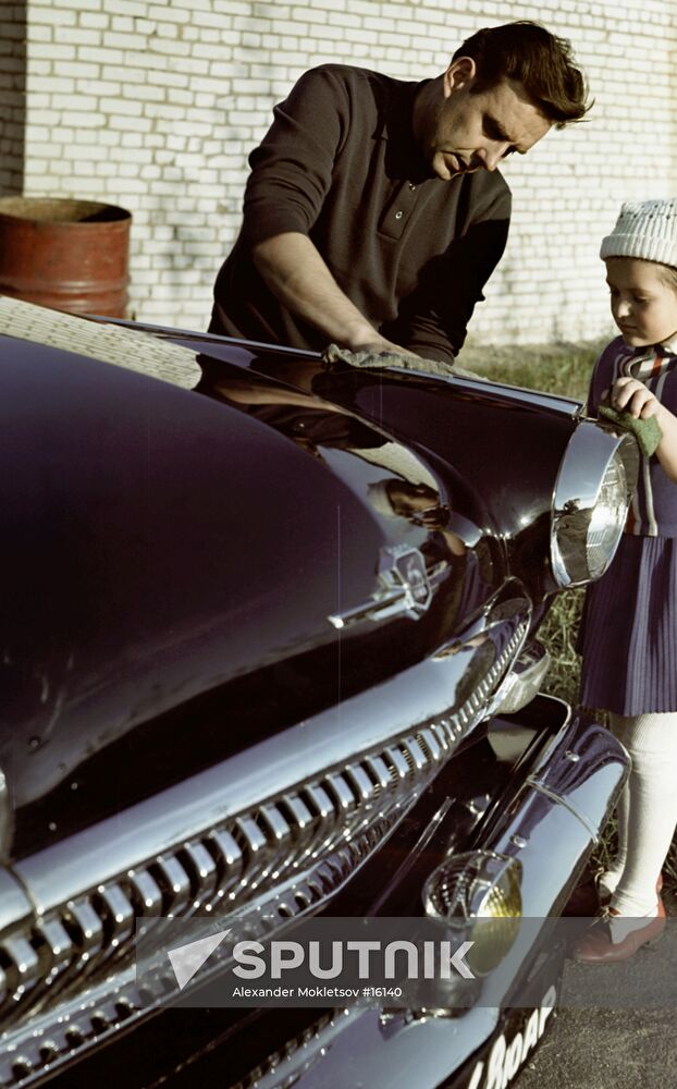 Vladimir Komarov and his daughter Irina wipe the car