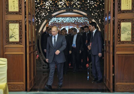 Vladimir Putin talks with Mahmoud Ahmadinejad