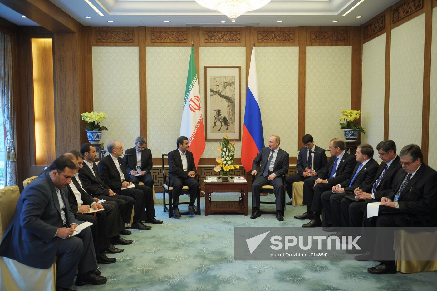 Vladimir Putin talks with Mahmoud Ahmadinejad