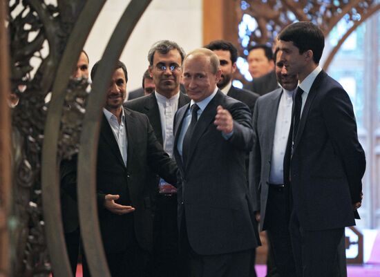 Vladimir Putin talks with Mahmoud Ahmadinejad