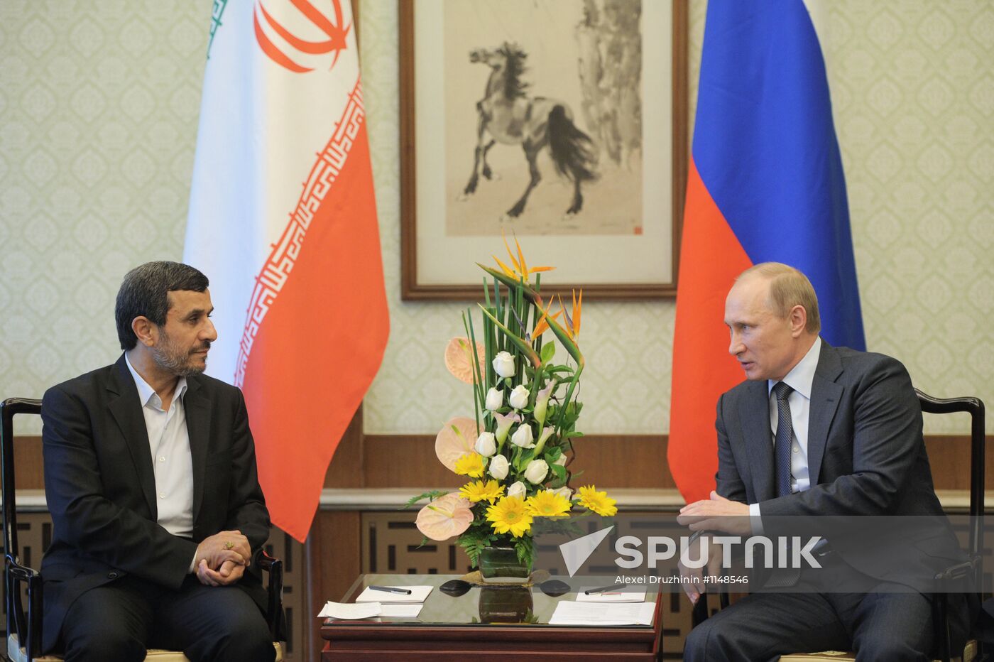 Vladimir Putin talks with Mahmoud Ahmadinejad