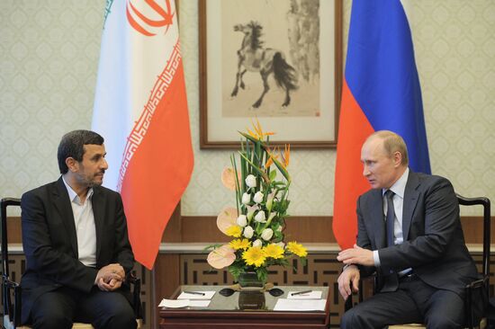 Vladimir Putin talks with Mahmoud Ahmadinejad