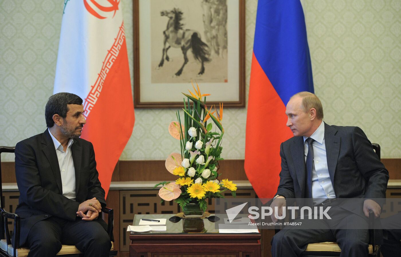 Vladimir Putin talks with Mahmoud Ahmadinejad
