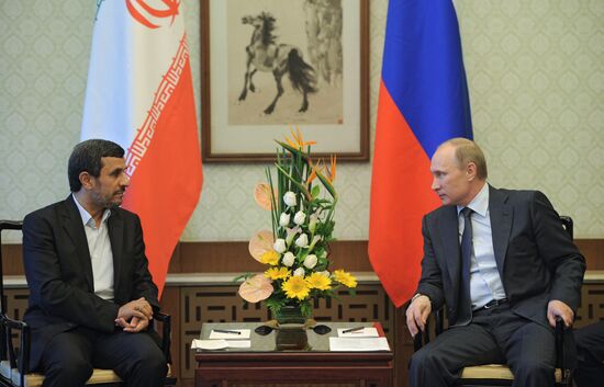 Vladimir Putin talks with Mahmoud Ahmadinejad