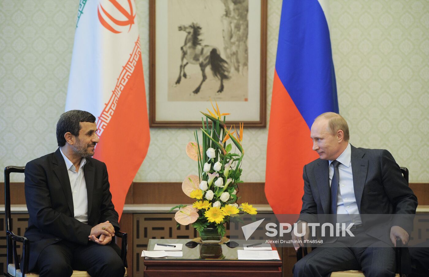 Vladimir Putin talks with Mahmoud Ahmadinejad