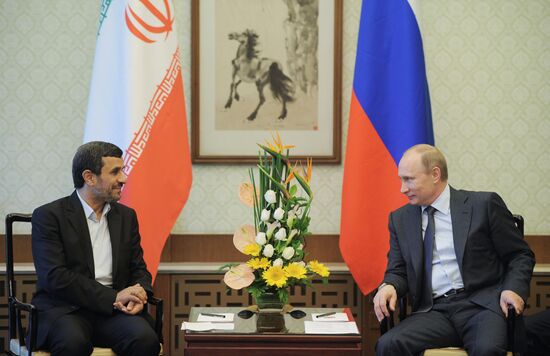 Vladimir Putin talks with Mahmoud Ahmadinejad