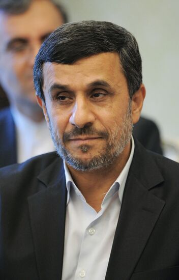Vladimir Putin talks with Mahmoud Ahmadinejad