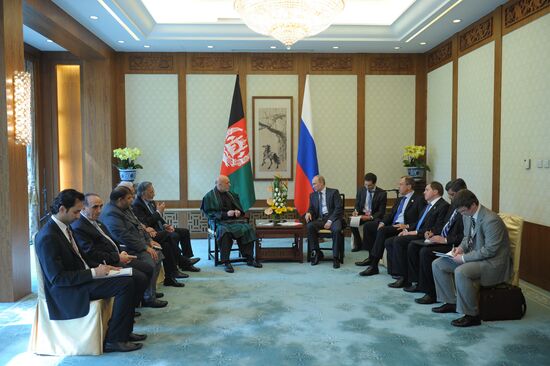 Vladimir Putin talks with Hamid Karzai