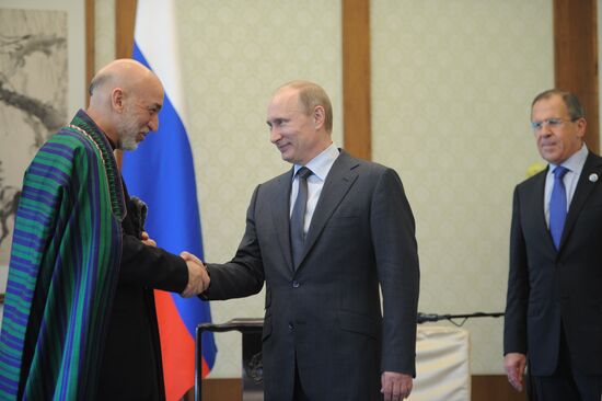 Vladimir Putin talks with Hamid Karzai