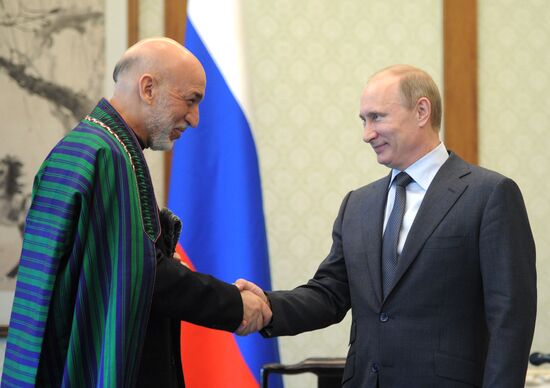 Vladimir Putin talks with Hamid Karzai
