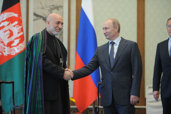 Vladimir Putin talks with Hamid Karzai