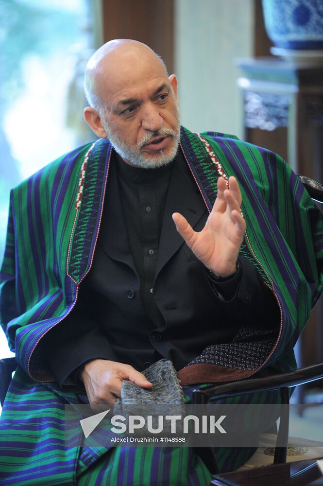 Vladimir Putin talks with Hamid Karzai