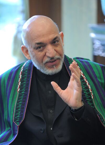 Vladimir Putin talks with Hamid Karzai