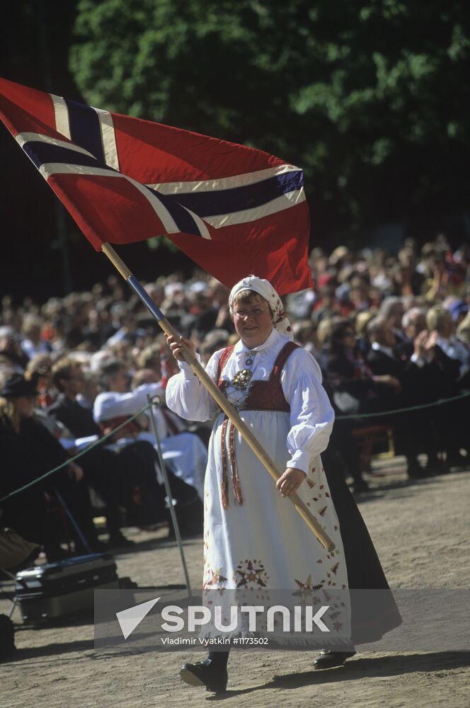 Norwegian woman wearing national dress and carrying a flag