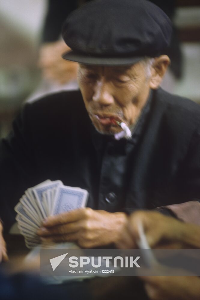 Elderly Chinese man playing cards