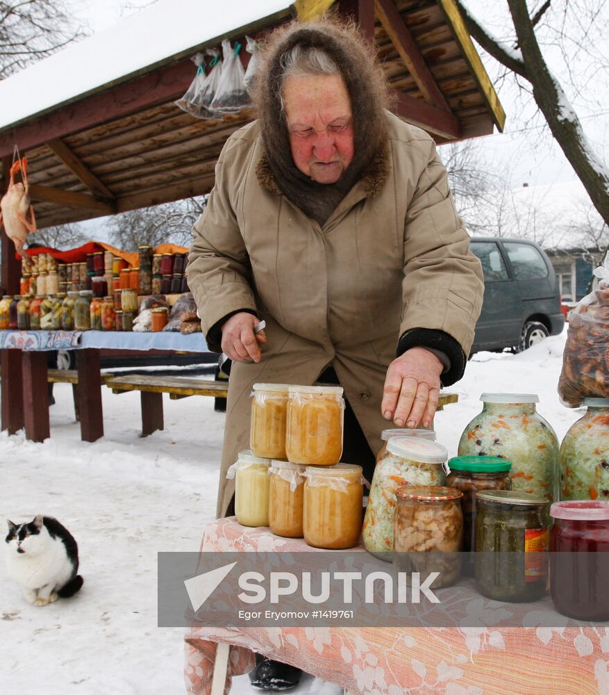 An elderly woman sells conservation at improvised market
