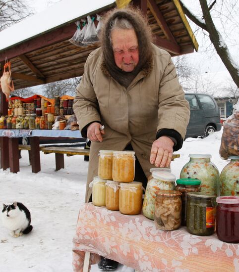 An elderly woman sells conservation at improvised market