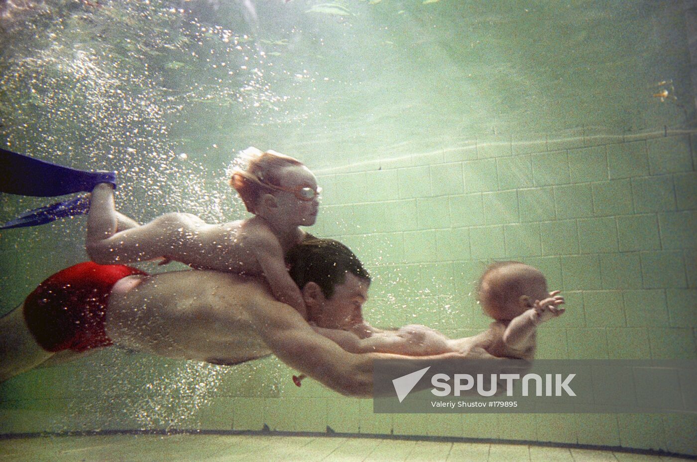 father children underwater swimming