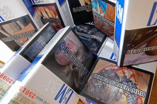 Cigarette packs with pictures warning of smoking consequences