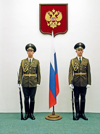 A guard of honor near the Russian flag and state emblem