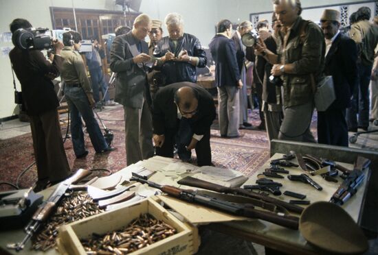 Journalists scrutinize the saboteurs’ weapons