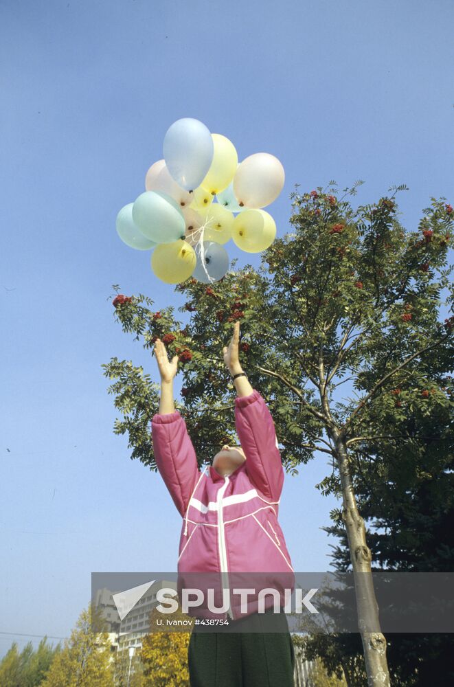 Child letting go of balloons