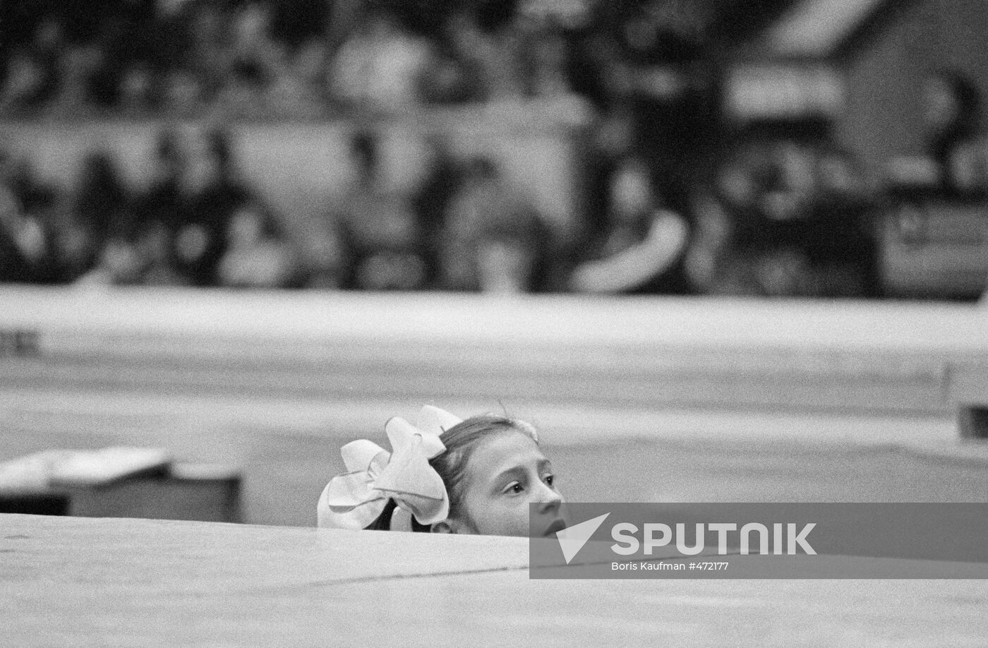 Girl watches artistic gymnastics competition