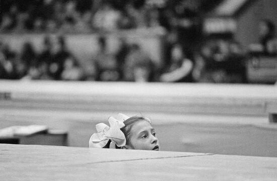 Girl watches artistic gymnastics competition