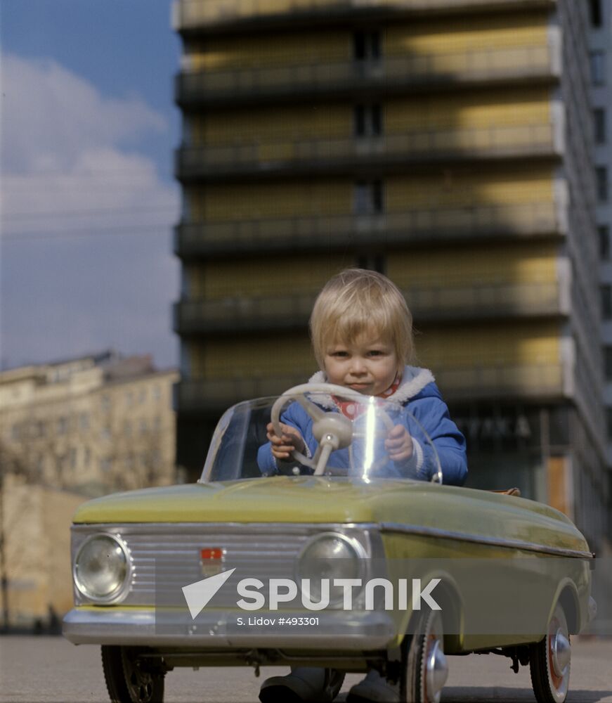 Child riding a toy car