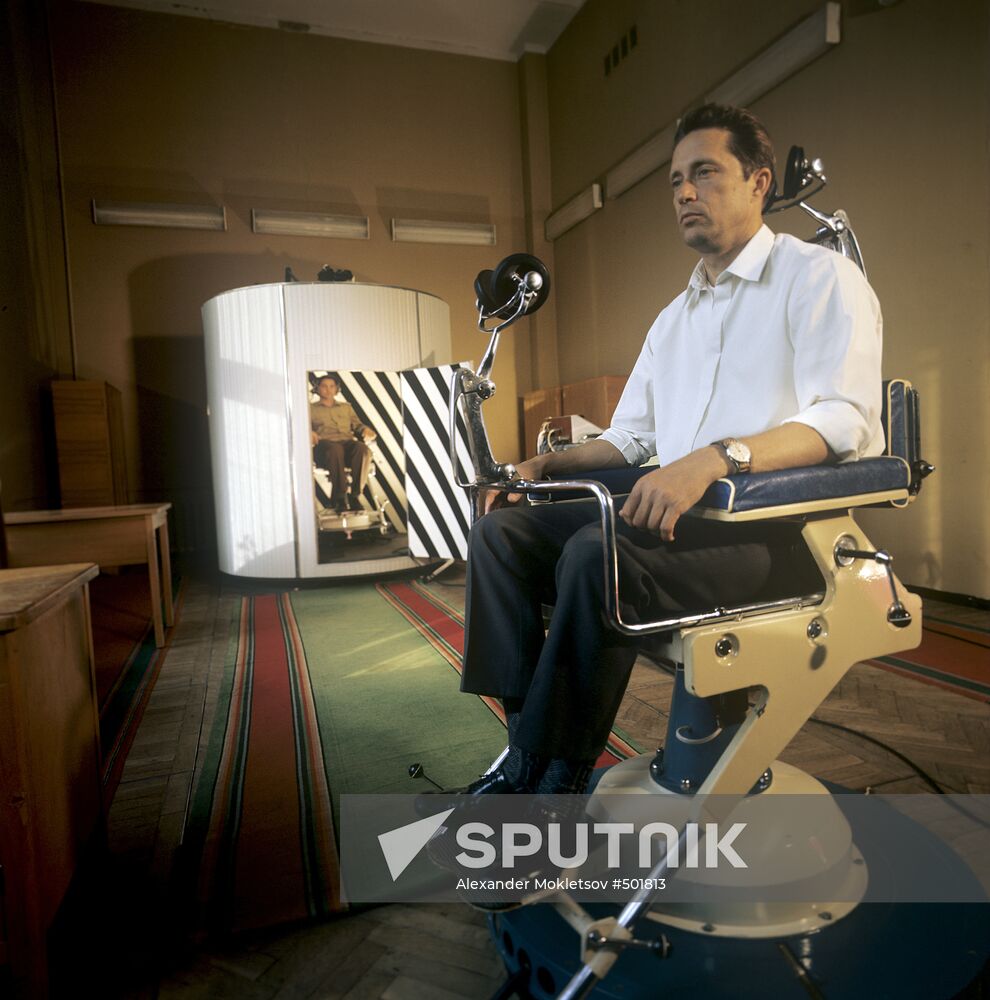 Onboard engineer Vladimir Aksyonov of spaceship Soyuz-22 undergoing medical training of his vestibular organ. Seen in the background is Valery Bykovsky, pilot-cosmonaut of the USSR and Hero of the Soviet Union