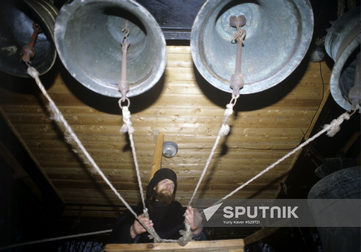 Monk Trophim is tolling the bells