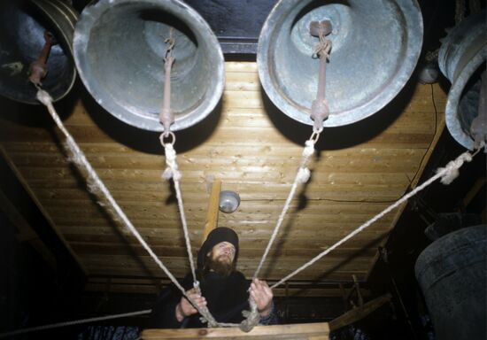 Monk Trophim is tolling the bells