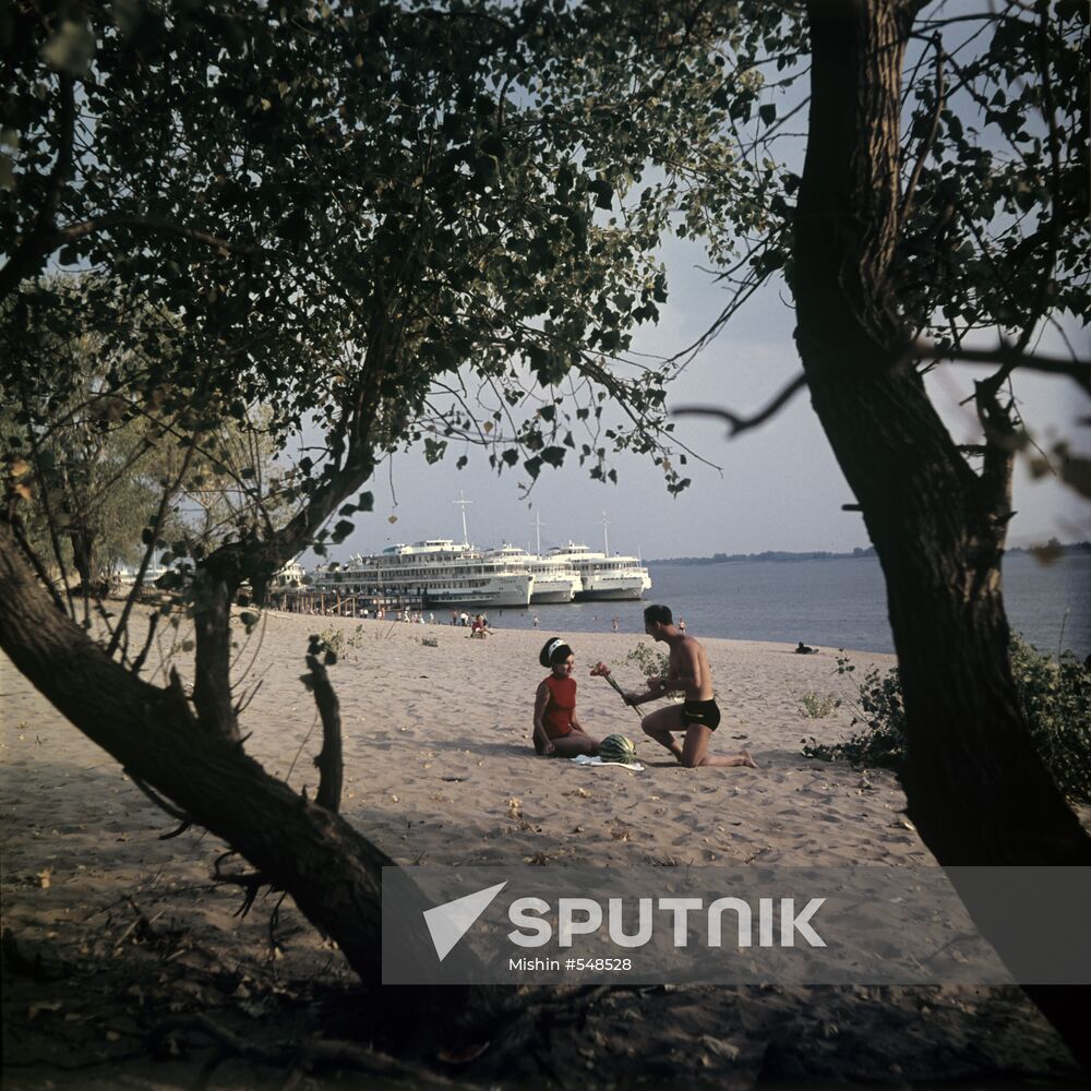Tourists on beach on bank of Volga
