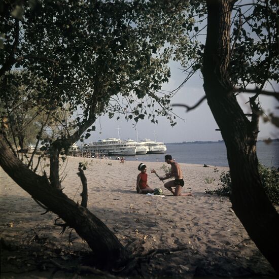 Tourists on beach on bank of Volga