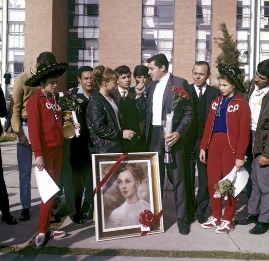 Painter presenting Natalia Kuchinskaya with her portrait