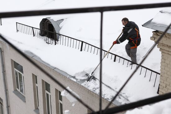 Removing snow and icicles from buildings in Smolensky Bulvar