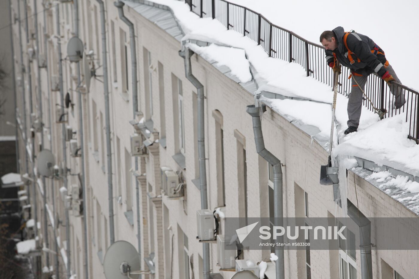Removing snow and icicles from buildings in Smolensky Bulvar