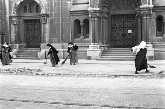Nuns sweeping debris after bombing