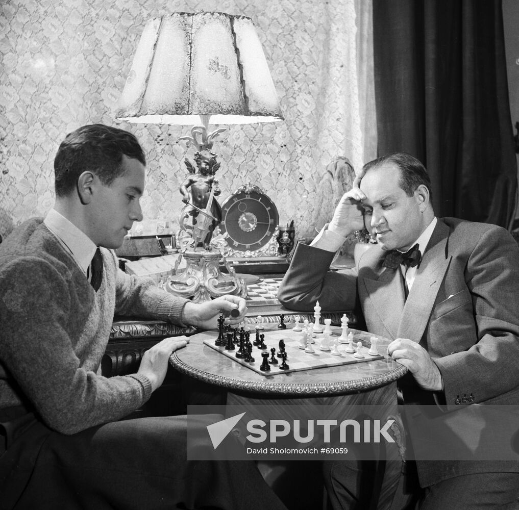 Violinists David Oistrakh and Igor Oistrakh playing chess. 