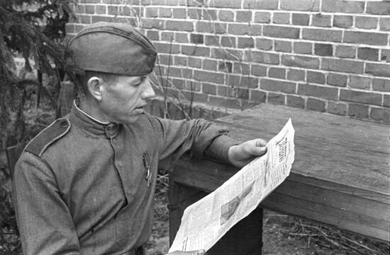Soldier reading newspaper