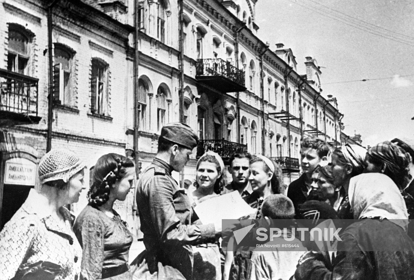 Soldier shows Pravda newspaper to city dwellers