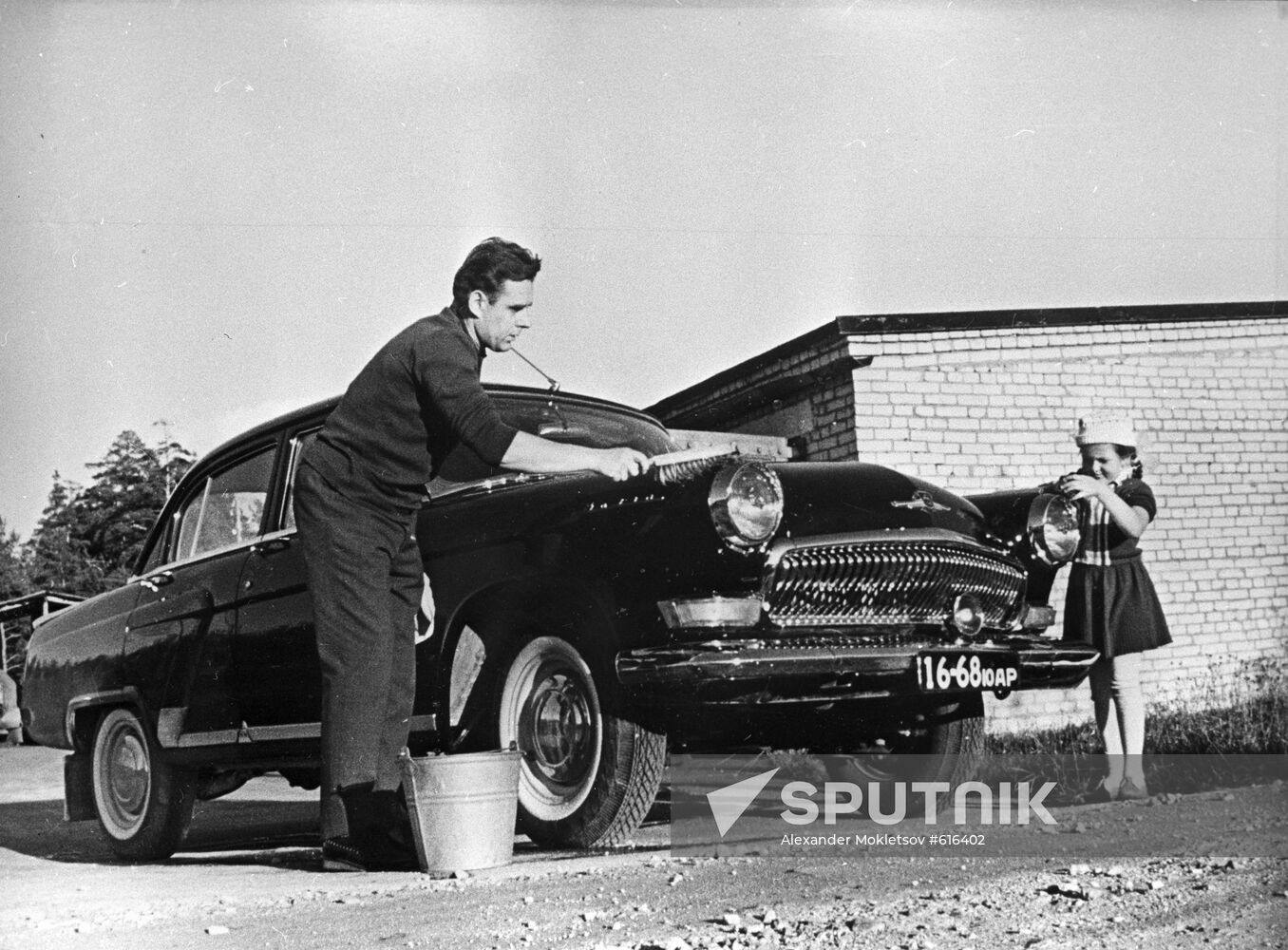 Vladimir Komarov washing his car with daughter Irina