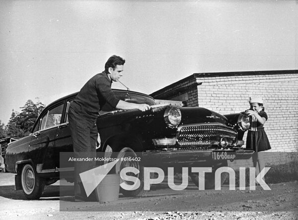 Vladimir Komarov washing his car with daughter Irina