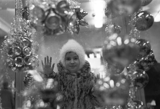 Girl by shop window of department store Detsky Mir