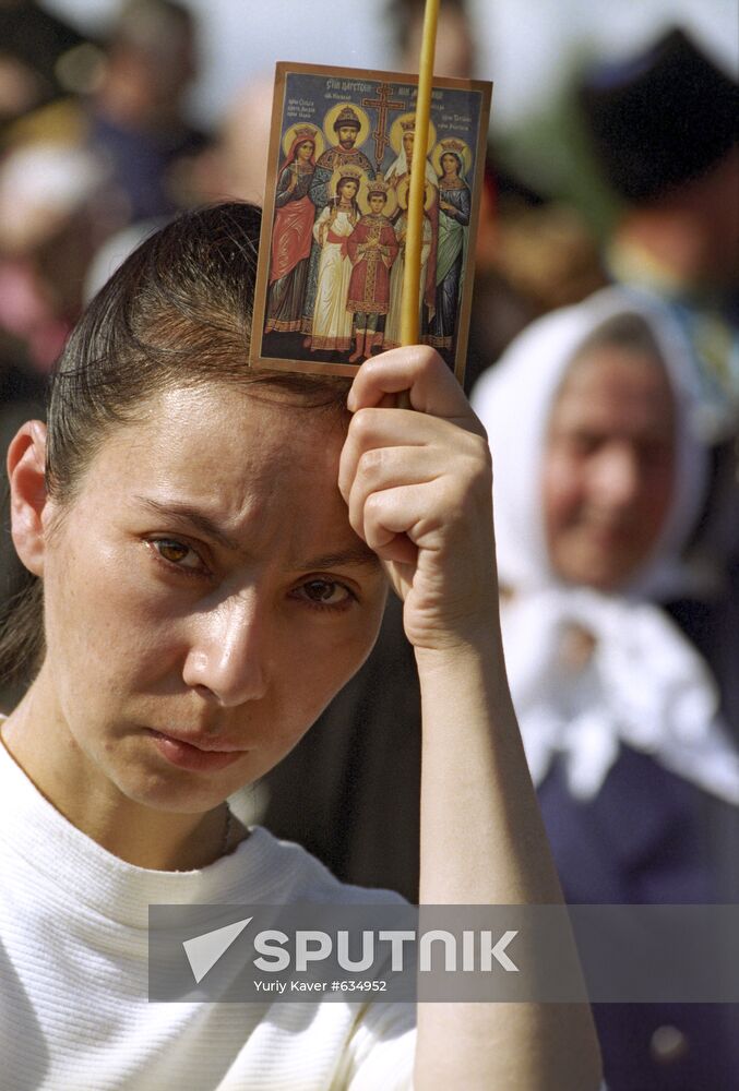Believer holds icon of Nicholas II and his family