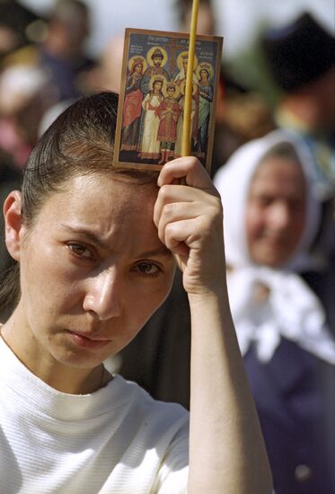 Believer holds icon of Nicholas II and his family