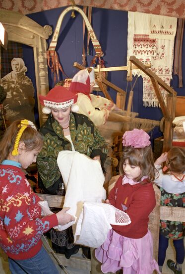 Young exhibition visitors next to display entitled "Weaving"
