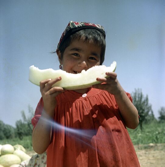 Tajik girl eating melon