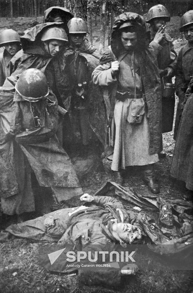 Soviet soldiers stand around body of killed German soldier